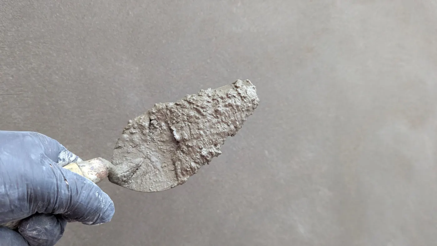 Nahaufnahme einer Spachtel beim Glätten einer Wand